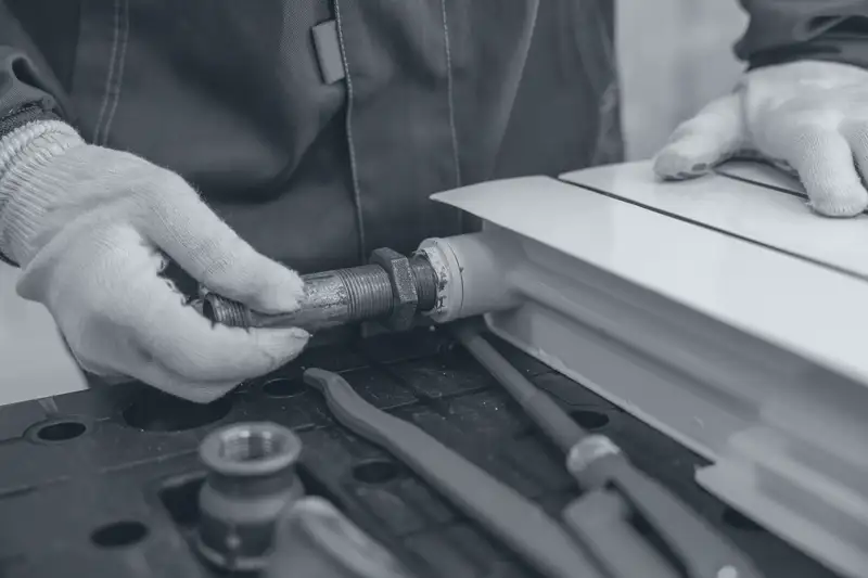 A plumber fitting a radiator pipe with a wrench